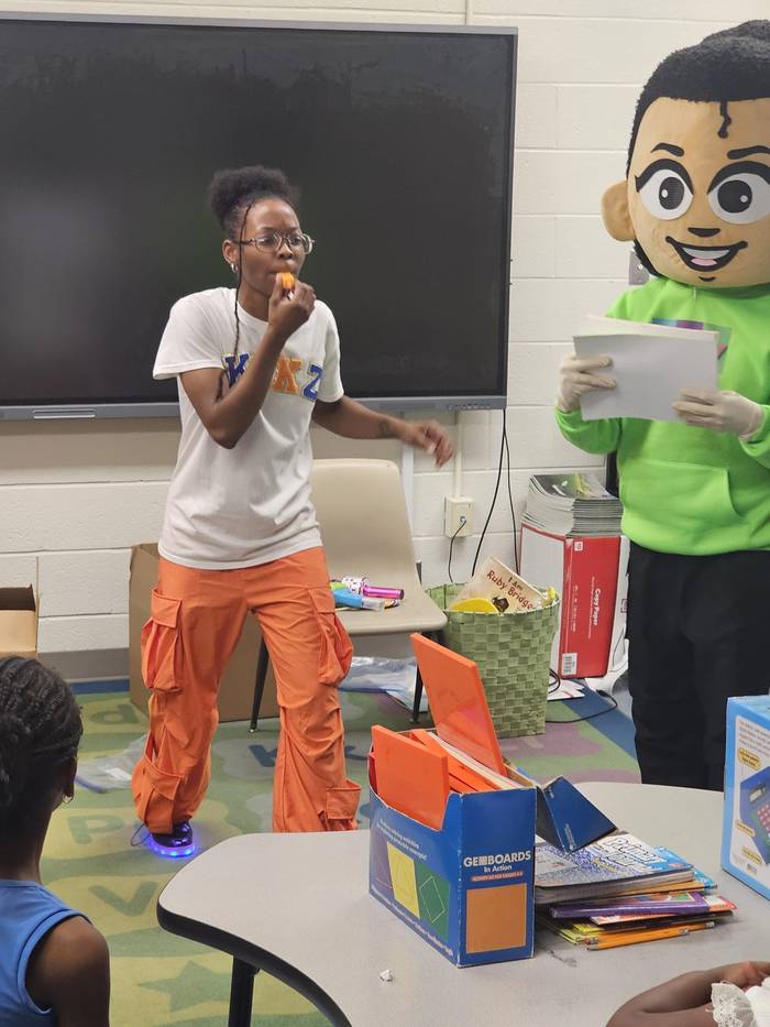 Emery and Kikz blow the whistle while engaging with young students