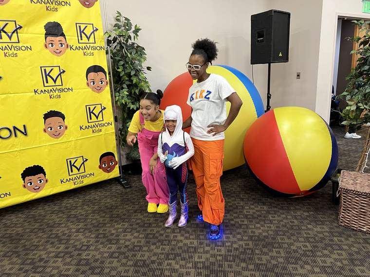 Maxi and Kikz pose for a photo with a young fan